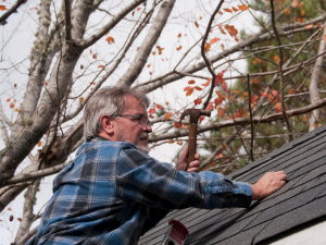 Done Right Roofing professionals in Austin repairing a damaged roof during the fall season.