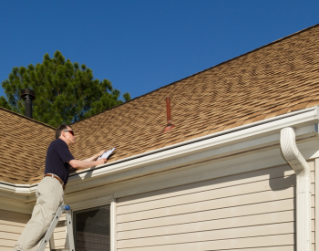 Bryan roofer inspecting roof for summer readiness